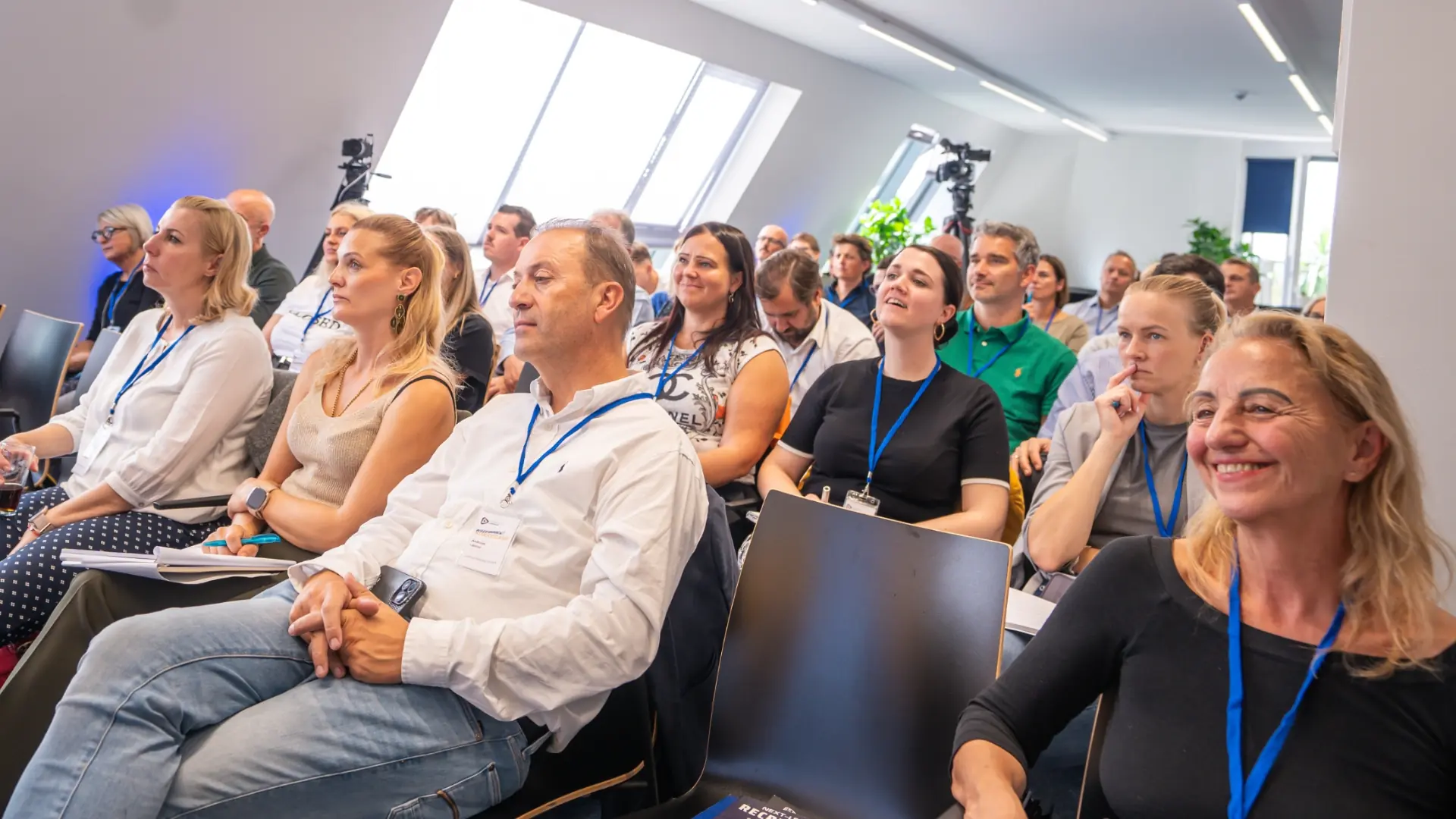 Professionelles Publikum bei einem Seminar in hellem Veranstaltungsraum