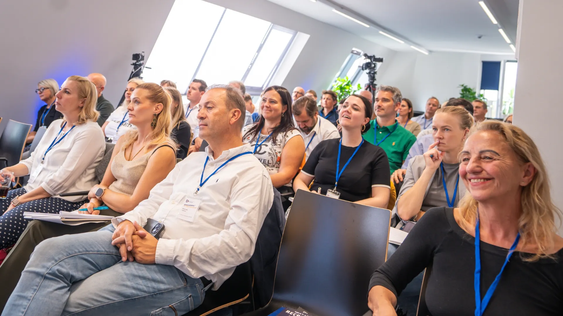 Professionelles Publikum bei einem Seminar in hellem Veranstaltungsraum