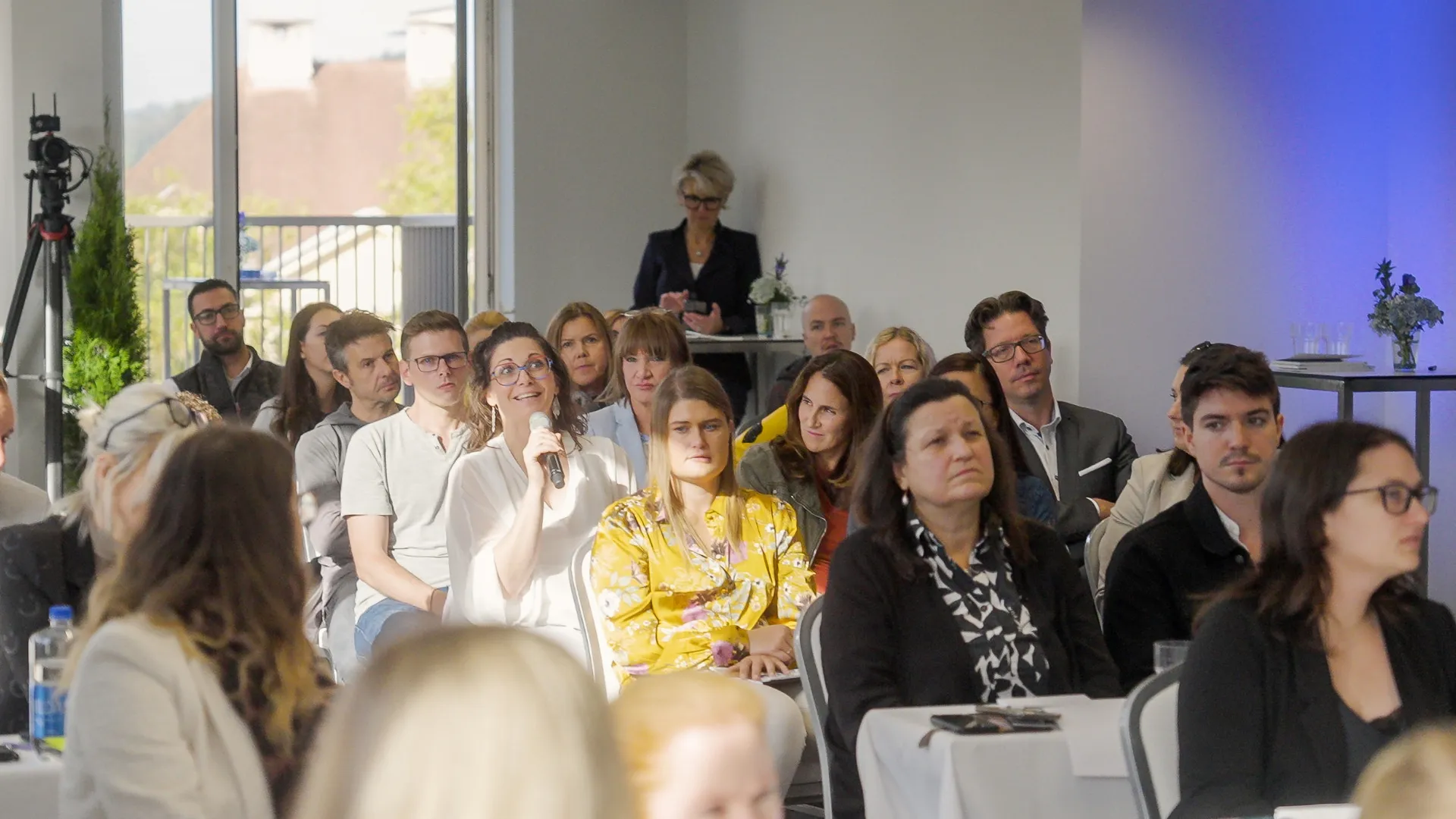 Diskussion im Publikum mit Handmikrofon während einer Veranstaltung