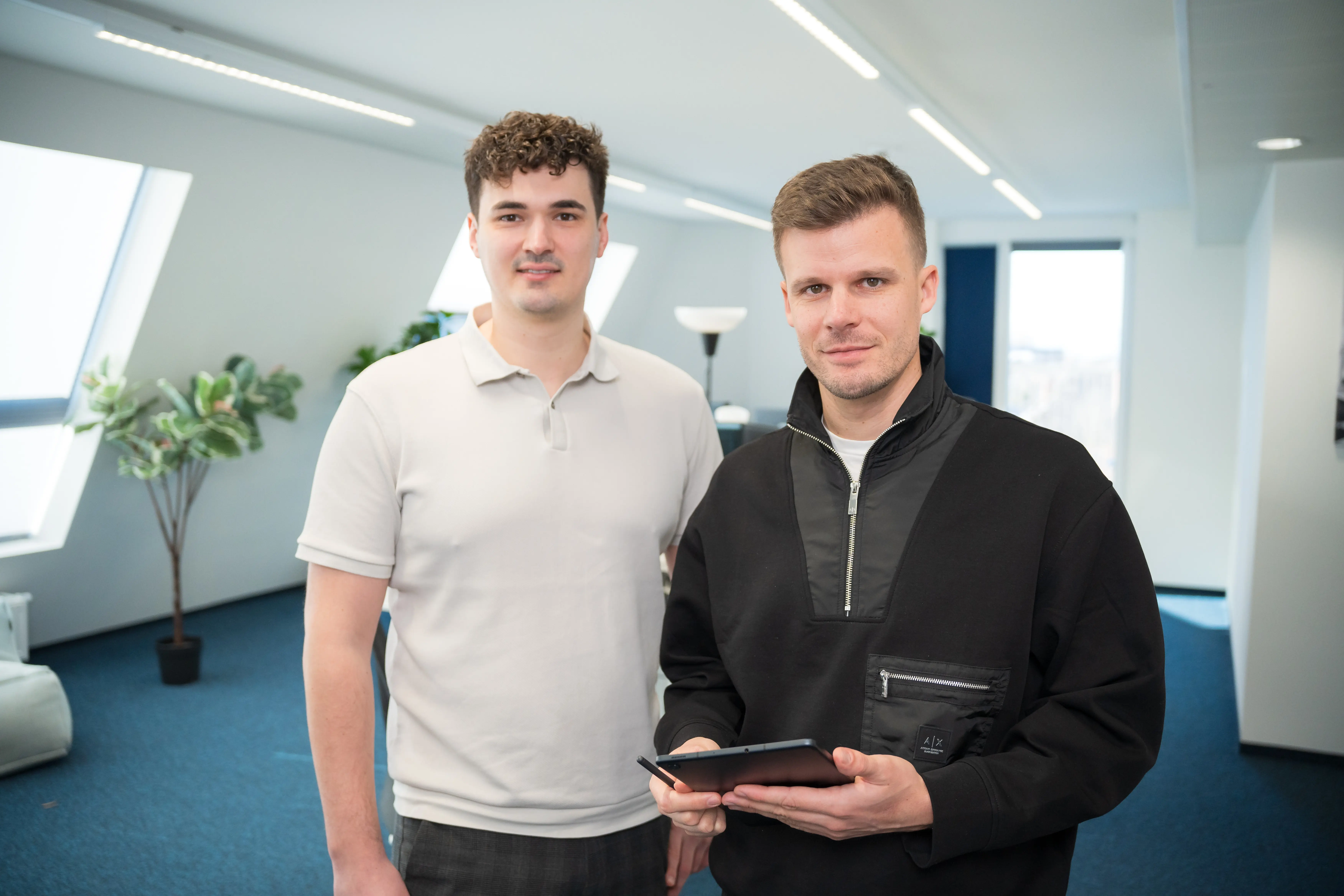 Zwei mediapool-Kollegen im hellen Büro, einer mit Tablet und Eingabestift